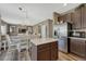 Open-concept kitchen featuring an island, stainless steel appliances, and a view into the living area at 18655 E Garden Pl, Aurora, CO 80015