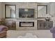 Contemporary living room area with a stone fireplace, a television, and custom cabinetry at 18655 E Garden Pl, Aurora, CO 80015