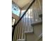 Elegant staircase featuring a chandelier and bright natural light from the adjacent windows at 18655 E Garden Pl, Aurora, CO 80015