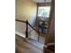Elegant staircase featuring hardwood floors, white railings, and a decorative chandelier at 18655 E Garden Pl, Aurora, CO 80015