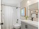 Bright bathroom featuring a shower-tub combo and sleek gray vanity with artwork at 3177 S Grant St, Englewood, CO 80113