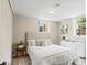 Basement bedroom with an egress window, white bed, and accent furniture at 3177 S Grant St, Englewood, CO 80113
