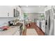 Modern open kitchen with white cabinets, stainless appliances, and breakfast bar overlooking the dining area at 3177 S Grant St, Englewood, CO 80113