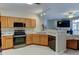 The kitchen has stainless appliances, wood cabinets, recessed lighting, and breakfast bar at 3281 E 103Rd Pl # 1403, Thornton, CO 80229