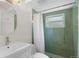 Bathroom featuring a modern vanity, round mirror, and shower with green tile surround at 5315 Newland St, Arvada, CO 80002