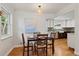 Bright dining room area with wood floors, updated lighting fixture, and seamless flow to the kitchen area at 5315 Newland St, Arvada, CO 80002