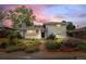 Charming white brick home with landscaped front yard and colorful dusk sky, adding to its curb appeal at 5315 Newland St, Arvada, CO 80002