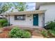 Inviting front porch features black iron supports, a vibrant door, and meticulously curated landscaping at 5315 Newland St, Arvada, CO 80002