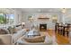 Cozy living room featuring a brick fireplace, hardwood floors, and an abundance of natural light for a warm atmosphere at 5315 Newland St, Arvada, CO 80002