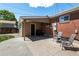 Back patio with a grill and chairs, with a view of the yard and the back of the brick house at 160 Northglenn Dr, Northglenn, CO 80233