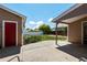 The backyard with an enclosed patio space and landscaping, and a detached garage with a red door at 160 Northglenn Dr, Northglenn, CO 80233