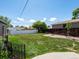 The backyard with a grassy lawn, with a white fence and a wood fence at the far end of the yard at 160 Northglenn Dr, Northglenn, CO 80233
