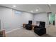 Finished basement featuring carpeted floors, two arm chairs, and natural lighting from the small window at 160 Northglenn Dr, Northglenn, CO 80233