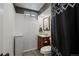 Cozy bathroom featuring white wainscoting, a charming vanity, and a modern shower curtain at 160 Northglenn Dr, Northglenn, CO 80233