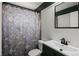 Stylish bathroom features floral shower curtain, wainscotting, and modern sink at 160 Northglenn Dr, Northglenn, CO 80233
