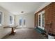Bright enclosed porch featuring white trim, exposed brick and a view of the backyard through windows and doors at 160 Northglenn Dr, Northglenn, CO 80233