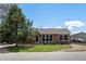 Charming brick home featuring a well-kept lawn, complemented by a lush tree and a detached garage at 160 Northglenn Dr, Northglenn, CO 80233