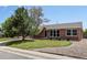 Beautiful brick home featuring a well-kept front yard and rock garden, complemented by a lush tree at 160 Northglenn Dr, Northglenn, CO 80233