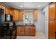 Cozy kitchen featuring oak cabinets, black appliances, and granite countertops with tile backsplash at 160 Northglenn Dr, Northglenn, CO 80233