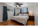 Bright main bedroom featuring hardwood floors, modern ceiling fan, and windows overlooking the landscaped yard at 160 Northglenn Dr, Northglenn, CO 80233