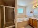 Bathroom featuring separate shower, soaking tub, and a glass block window at 395 Longspur Dr, Brighton, CO 80601