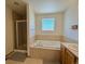 Bathroom featuring separate shower, soaking tub, and a glass block window at 395 Longspur Dr, Brighton, CO 80601