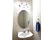 Clean powder room featuring a pedestal sink, oval mirror, and fresh blue towel at 395 Longspur Dr, Brighton, CO 80601