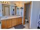 Bathroom featuring double sinks, wood cabinets, and a well-lit vanity at 395 Longspur Dr, Brighton, CO 80601
