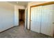 Bedroom with double door closet and access to a hallway at 395 Longspur Dr, Brighton, CO 80601