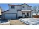 Two-story house with attached garage and backyard, snow on the ground at 395 Longspur Dr, Brighton, CO 80601