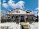 Two-story home with a large front porch and snowy yard at 395 Longspur Dr, Brighton, CO 80601