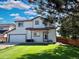 Two-story home with an attached garage, nice lawn, and convenient side entrance at 395 Longspur Dr, Brighton, CO 80601