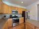Kitchen featuring an island with stools, stainless steel appliances, and wooden cabinets at 395 Longspur Dr, Brighton, CO 80601