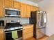 Kitchen with stainless steel oven range, wooden cabinets and stainless steel refrigerator at 395 Longspur Dr, Brighton, CO 80601