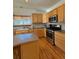 Kitchen with stainless steel appliances, wooden cabinets, and an island at 395 Longspur Dr, Brighton, CO 80601