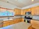 Well-lit kitchen featuring wooden cabinets, stainless steel appliances, and tile backsplash at 395 Longspur Dr, Brighton, CO 80601
