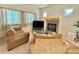 Inviting living room featuring a stone fireplace, large windows, and neutral carpeting at 395 Longspur Dr, Brighton, CO 80601