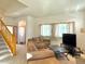 Living room with beige sofas, large windows, and neutral carpet, creating a warm and inviting space at 395 Longspur Dr, Brighton, CO 80601