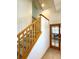 Well-lit carpeted staircase with wooden railing, leading to the upper level at 395 Longspur Dr, Brighton, CO 80601