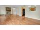 Open-concept living room with stone fireplace, hardwood floors, and access to kitchen and dining area at 4425 S Zang St, Morrison, CO 80465