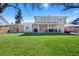 Expansive backyard with lush green lawn, covered patio, and traditional brick exterior at 5775 S Pagosa Way, Centennial, CO 80015