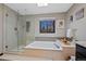 This luxurious bathroom offers a large soaking tub and glass enclosed shower with bright light from skylight and window at 5775 S Pagosa Way, Centennial, CO 80015