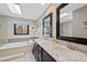 This bathroom features double sinks, modern black framed mirrors, and a skylight at 5775 S Pagosa Way, Centennial, CO 80015