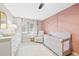 This modern baby's bedroom provides a pink accent wall, comfortable chair, and crib at 5775 S Pagosa Way, Centennial, CO 80015