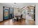 Cozy dining area with backyard access leading into a spacious living room with beamed ceilings at 5775 S Pagosa Way, Centennial, CO 80015