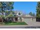 Charming two-story home featuring a brick and siding exterior, a well-manicured lawn, and an attached three-car garage at 5775 S Pagosa Way, Centennial, CO 80015