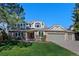 Charming two-story home with brick and siding, lush lawn, and a three car attached garage at 5775 S Pagosa Way, Centennial, CO 80015