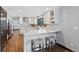 Bright kitchen features white cabinets, marble countertops, and seating at the island, seamlessly blending style and functionality at 5775 S Pagosa Way, Centennial, CO 80015