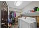 Functional laundry room with slate floors, washer, dryer, and organized storage at 5775 S Pagosa Way, Centennial, CO 80015