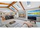 Bright living room featuring beamed ceilings, a comfortable gray sofa, a large window and kitchen access at 5775 S Pagosa Way, Centennial, CO 80015